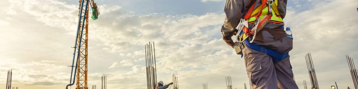 A construction worker control a pouring concrete pump on construction site and sunset background